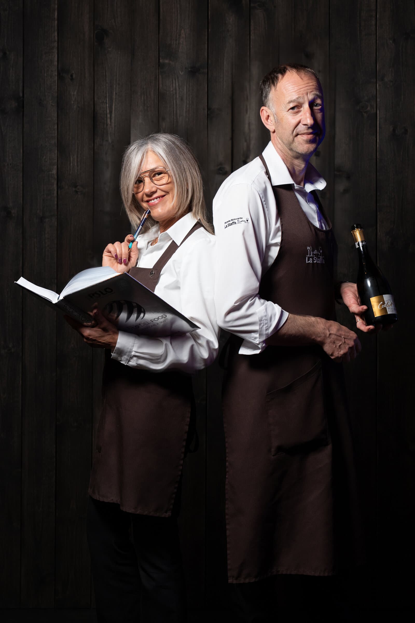 Il capo sala e la sua assistente de La Staffa: lui con una bottiglia di vino, lei con il libro dei vini
